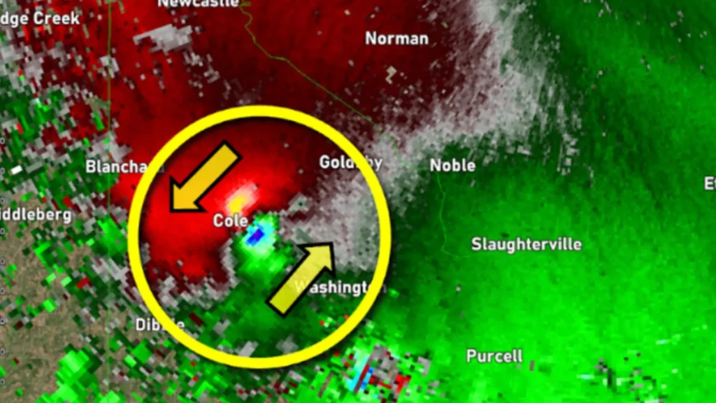 A screen grab of a Doppler radar velocity image showing contrasting colors very close together, indicating winds moving toward and away from the radar position that denote rotation and a potential or actual tornado. 