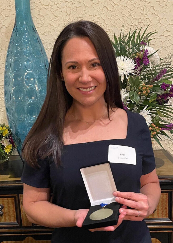 Erica Grow Cei holding an award