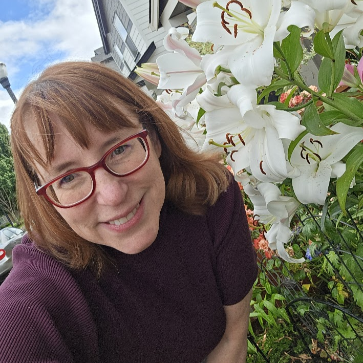 Photo of Tanja Fansen in a garden with white lilies.