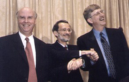 Craig Venter, Ari Patrinos, and Francis Collins (director of the National Human Genome Research Institute) smiling and holding hands at a White House event in 2000 celebrating the Human Genome Project