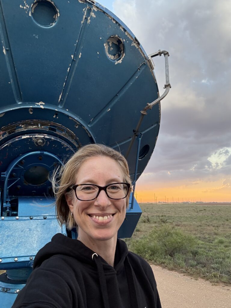 Photo of a smiling woman (Jen Walton) in front of a blue weather radar