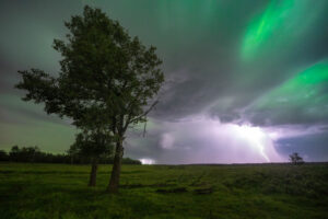 A gorgeous night with a kp 7 aurora dancing through the clouds of an electrifying lightning storm out at Elk Island National Park.